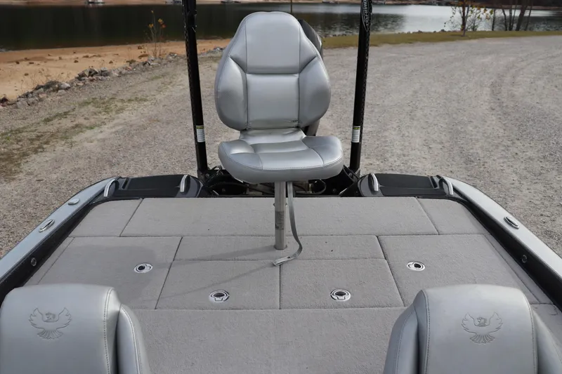 Slide: The Image of 2020 Phoenix 21 PHX boat interior with gray seating and fishing deck by a lake. - 7