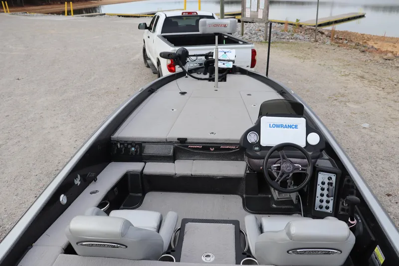 Slide: The Image of 2020 Phoenix 21 PHX boat interior with Lowrance system, parked by a lake. - 9