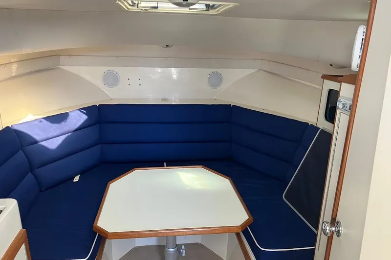 Slide: The Image of Interior of 2000 Albin 28 Tournament boat with blue cushioned seating and table. - 2