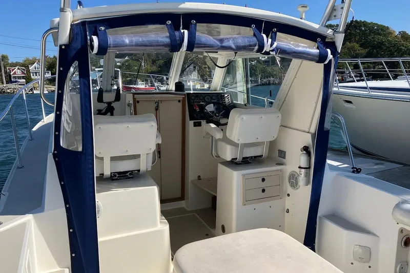 Slide: The Image of 2000 Albin 28 Tournament boat interior with helm and seating, docked by the water. - 5