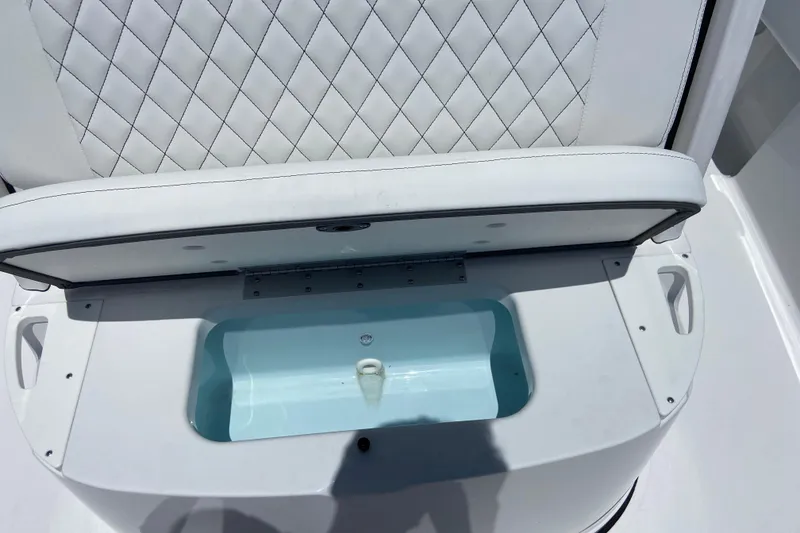 Slide: The Image of 2026 Sportsman Masters 227 Bay Boat seat with storage compartment open. - 29