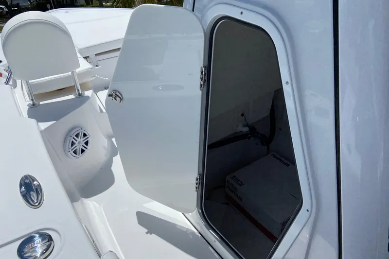 Slide: The Image of 2026 Sportsman Masters 227 Bay Boat interior storage compartment with open door. - 30