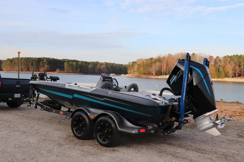 Slide: The Image of 2019 Bass Cat Lynx boat on trailer by a scenic lake. - 18