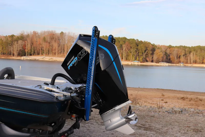 Slide: The Image of 2019 Bass Cat Lynx boat with Mercury Pro XS engine by a serene lake. - 19