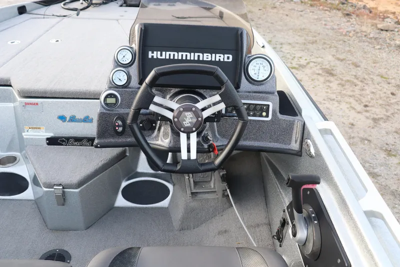 Slide: The Image of 2019 Bass Cat Lynx boat cockpit with steering wheel and Humminbird electronics. - 9