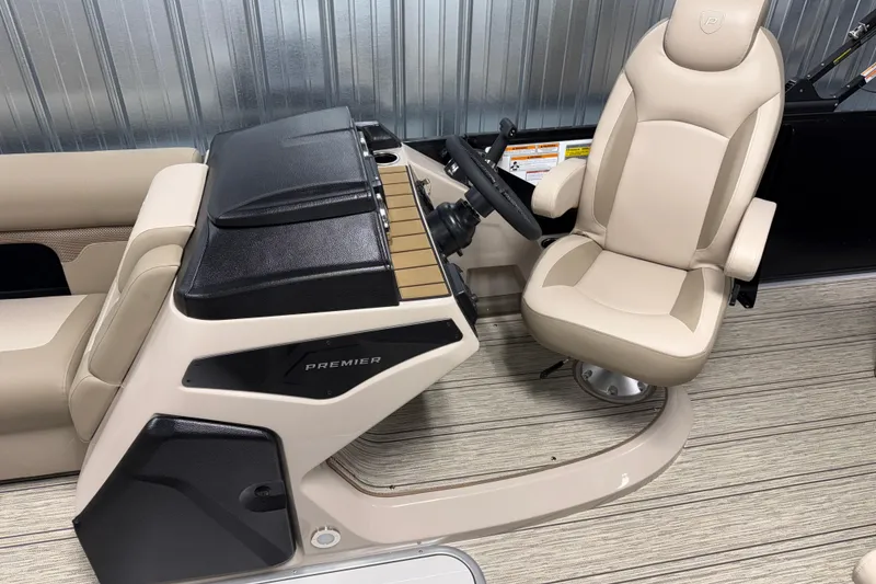 Slide: The Image of 2026 Premier 230 Sunsation RL Tritoon helm with beige captain's chair and steering console. - 15