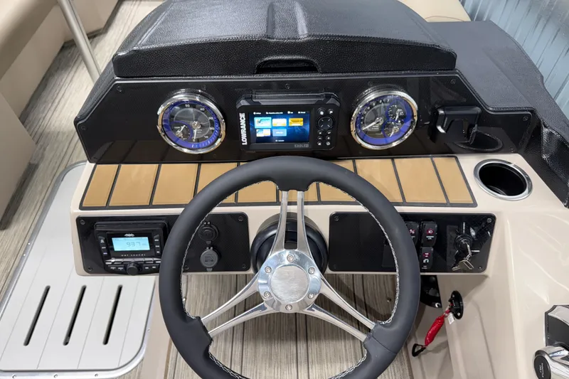 Slide: The Image of 2026 Premier 230 Sunsation RL Tritoon dashboard with steering wheel, gauges, and navigation system. - 16