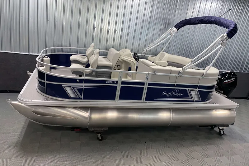 The Image of 2026 SunChaser Vista 18 Fish pontoon boat with blue and white design in showroom. - 0