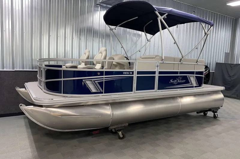 Slide: The Image of 2026 SunChaser Vista 18 Fish pontoon boat with blue exterior and canopy in showroom. - 15
