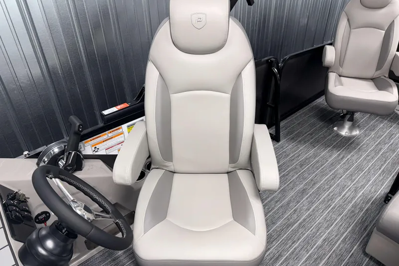 Slide: The Image of 2026 Premier 230 Sunsation Angler Tritoon interior with plush captain's chair and steering wheel. - 19