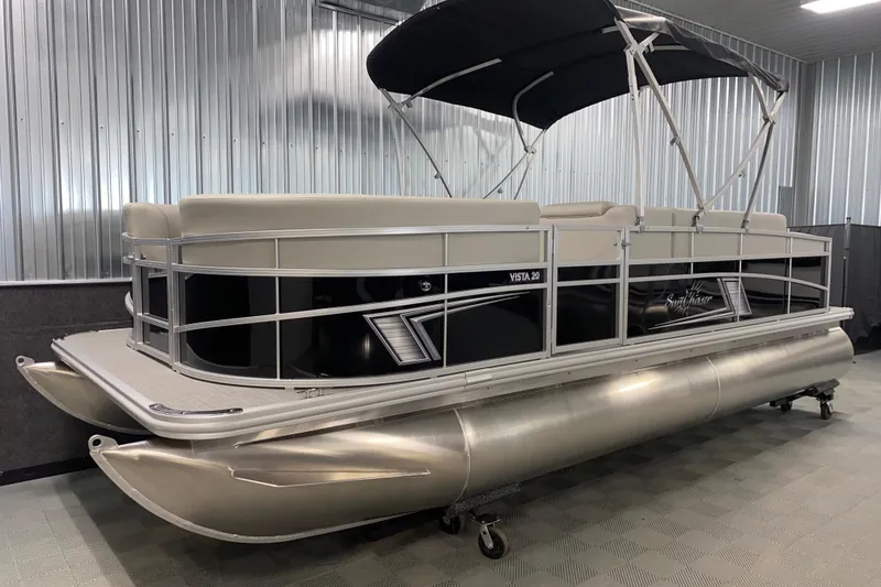 Slide: The Image of 2026 SunChaser Vista 20 CRB pontoon boat in showroom with black canopy. - 13