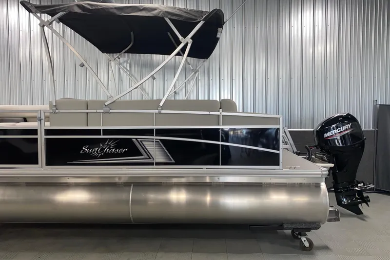 Slide: The Image of 2026 SunChaser Vista 20 CRB pontoon boat with Mercury outboard motor in showroom. - 17