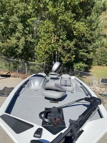 Slide: The Image of 2023 G3 Sportsman 1710 boat with seating, trolling motor, and lush green background. - 8