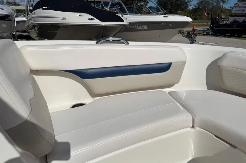 Slide: The Image of Interior seating of a 2011 Chaparral 186 SSi boat, featuring white and blue upholstery. - 15