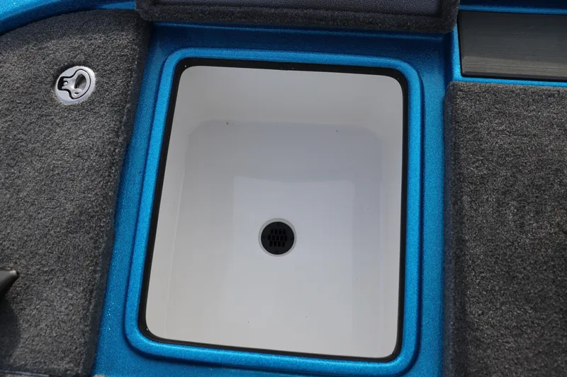 Slide: The Image of Livewell compartment in 2026 Falcon Boats F205, featuring blue trim and carpeted edges. - 13