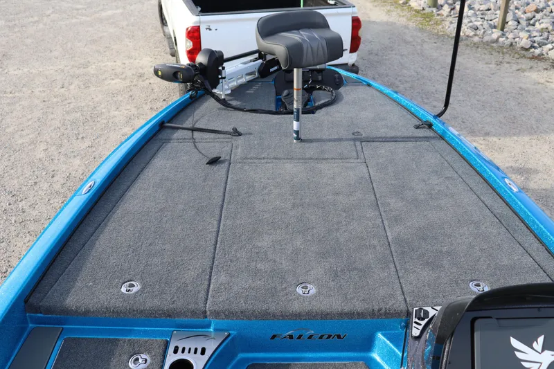 Slide: The Image of 2026 Falcon Boats F205 fishing deck with seat and trolling motor, parked near a truck. - 7