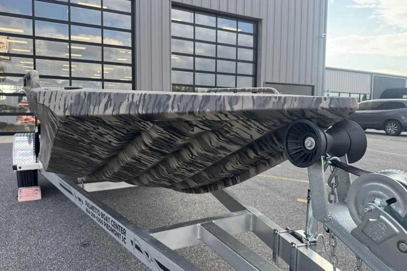 Slide: The Image of 2026 Havoc 1756 boat on trailer, featuring a camouflage design, parked outside a building. - 5