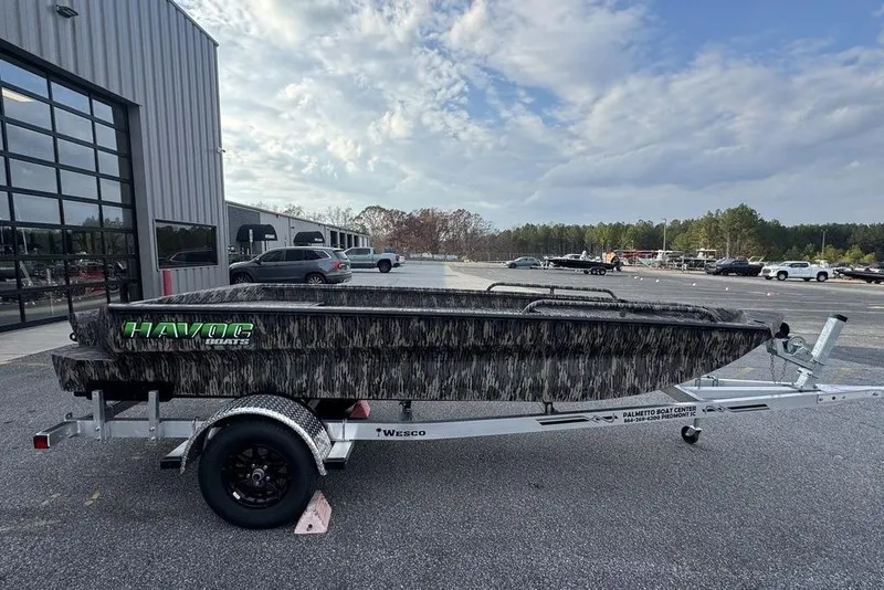 The Image of 2026 Havoc 1756 boat on trailer outside dealership under cloudy sky. - 0