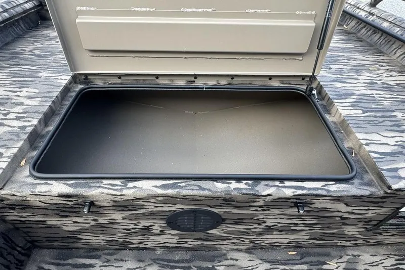 Slide: The Image of Open storage compartment in 2026 Havoc 1756 boat, featuring camo-patterned interior. - 12