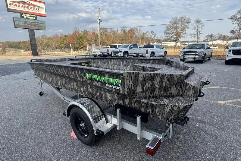 Slide: The Image of 2026 Havoc 1756 boat with camouflage design on a trailer in a parking lot. - 2