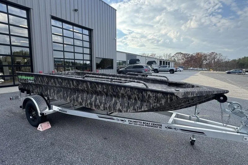 Slide: The Image of 2026 Havoc 1756 boat on trailer outside dealership, camo design, clear sky. - 6