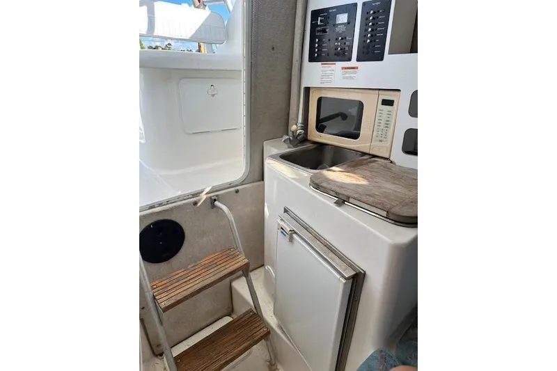 Slide: The Image of Interior of 2005 Sea Fox 287 Walkaround boat with kitchenette and wooden steps. - 23