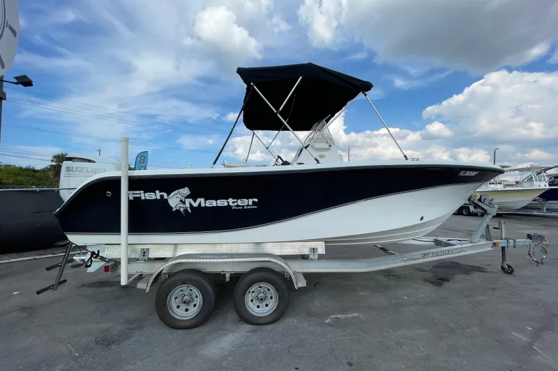 Slide: The Image of 2004 Fishmaster Travis Edition 220 boat on trailer under blue sky. - 10