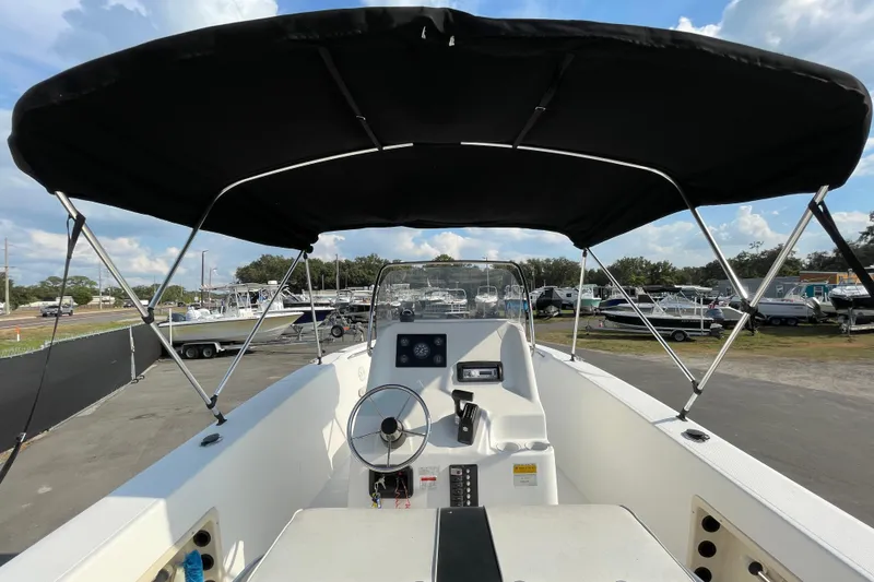 Slide: The Image of 2004 Fishmaster Travis Edition 220 boat with canopy, steering wheel, and control panel. - 18