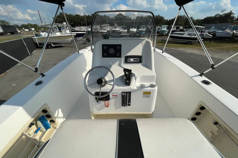 Slide: The Image of 2004 Fishmaster Travis Edition 220 boat cockpit with steering wheel and control panel. - 20