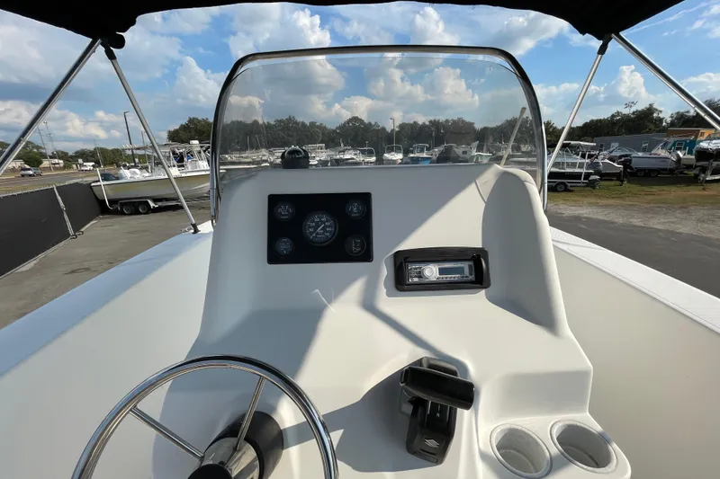 Slide: The Image of 2004 Fishmaster Travis Edition 220 boat dashboard with steering wheel and gauges. - 23