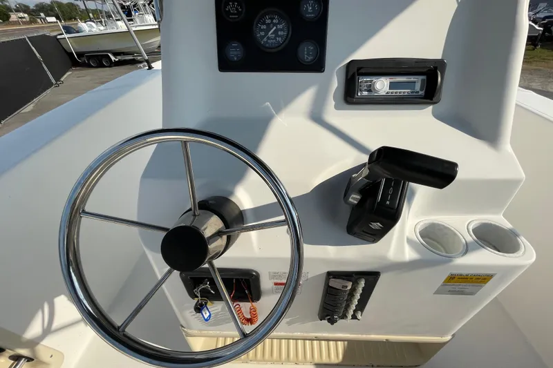 Slide: The Image of 2004 Fishmaster Travis Edition 220 boat console with steering wheel and controls. - 24