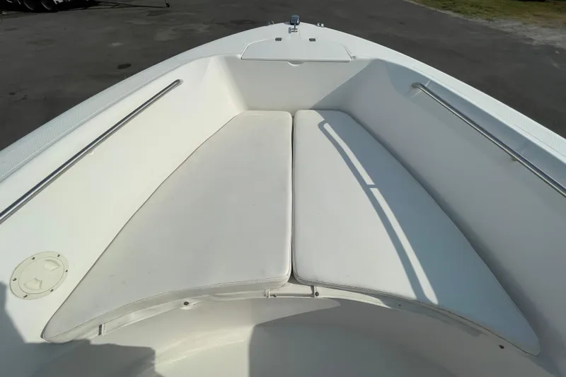 Slide: The Image of Bow seating area of 2004 Fishmaster Travis Edition 220 boat, featuring white cushions. - 36