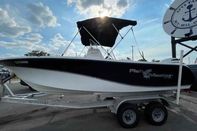 Slide: The Image of 2004 Fishmaster Travis Edition 220 boat on trailer under a sunny sky. - 4