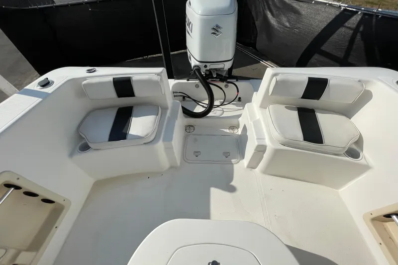 Slide: The Image of 2004 Fishmaster Travis Edition 220 boat interior with seating and Suzuki outboard motor. - 55
