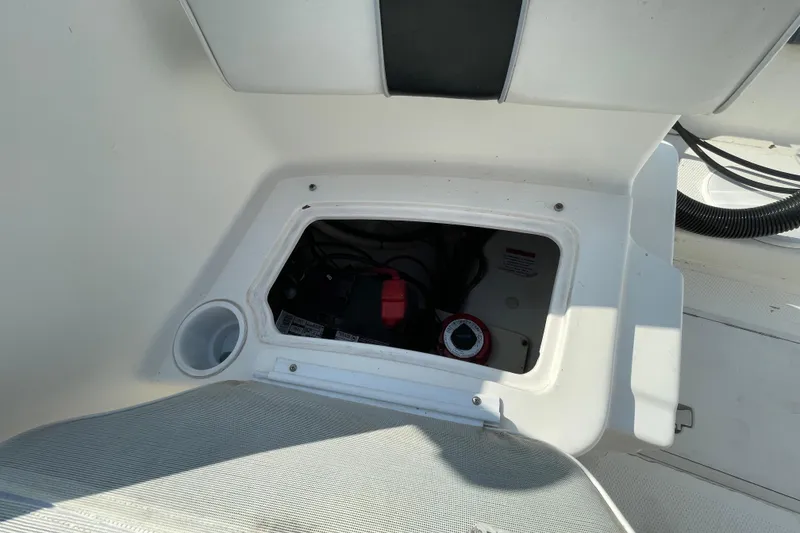 Slide: The Image of Open storage compartment on 2004 Fishmaster Travis Edition 220 boat, showing interior components. - 58