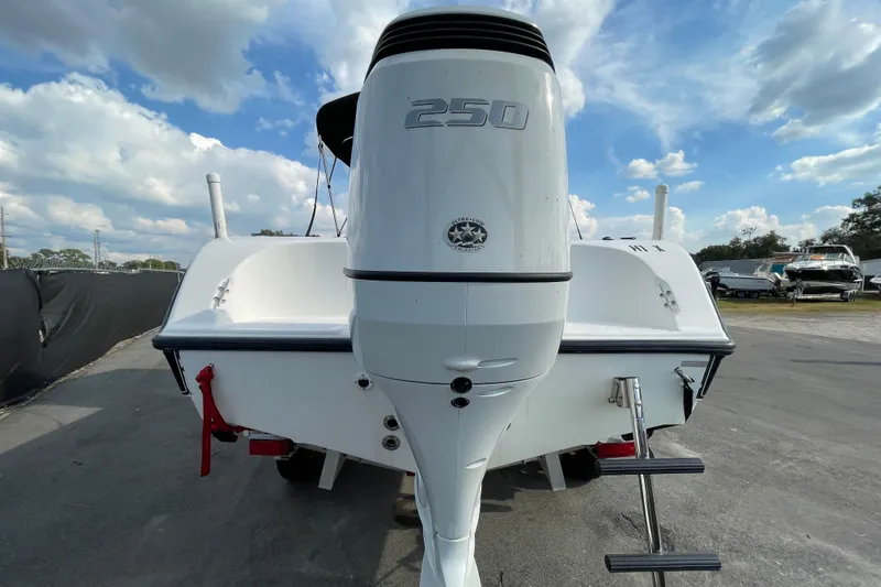 Slide: The Image of 2004 Fishmaster Travis Edition 220 boat with powerful 250 outboard motor, parked outdoors. - 6