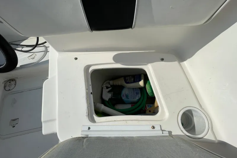 Slide: The Image of Storage compartment on a 2004 Fishmaster Travis Edition 220 boat, containing cleaning supplies. - 61