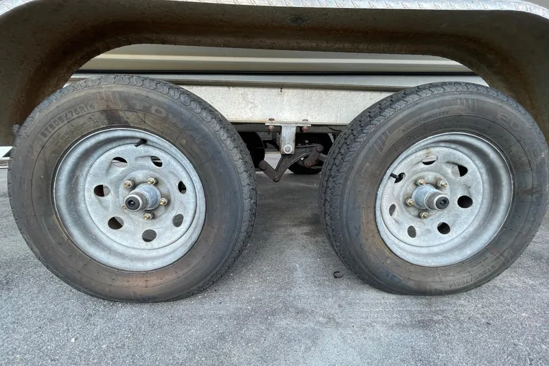 Slide: The Image of Trailer wheels of a 2004 Fishmaster Travis Edition 220 boat on pavement. - 64