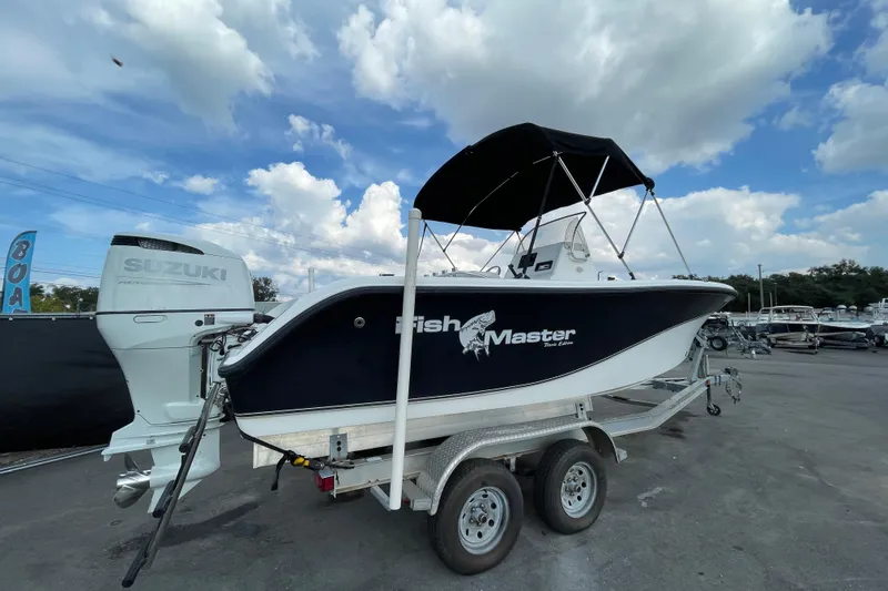 Slide: The Image of 2004 Fishmaster Travis Edition 220 boat on trailer, featuring Suzuki outboard motor. - 9