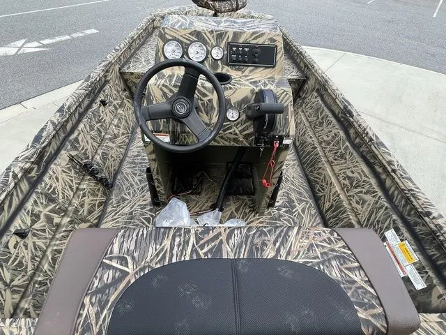 Slide: The Image of 2023 Crestliner 1860 Retriever CC boat interior with camo design and steering console. - 5