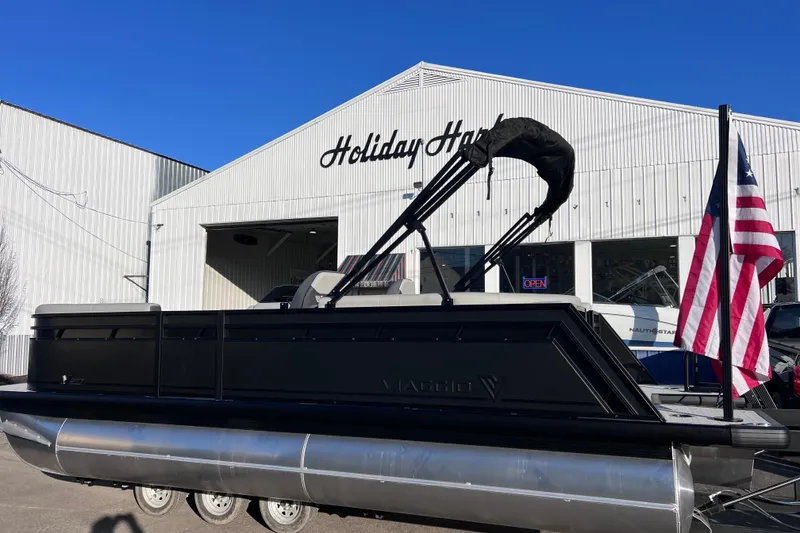 Slide: The Image of 2026 Viaggio V 20U pontoon boat at Holiday Harbor with American flag. - 2