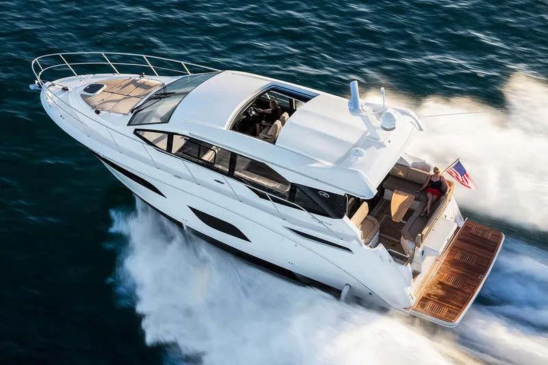 Slide: The Image of 2017 Sea Ray Sundancer 460 docked in a marina under a covered slip. - 2