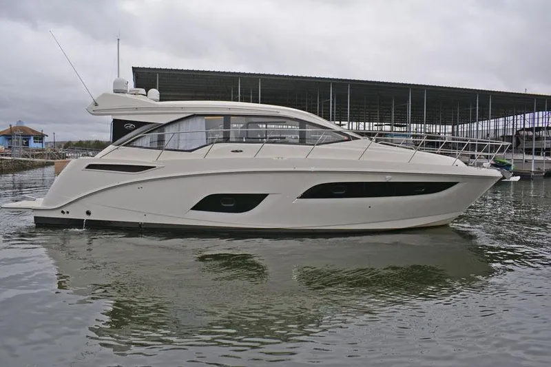 Slide: The Image of 2017 Sea Ray Sundancer 460 yacht docked, featuring covered seating area and spacious deck. - 26