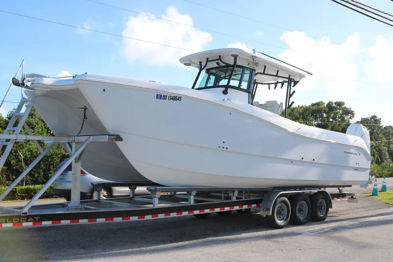 The Image of 2024 World Cat 325 CC boat on trailer, parked outdoors under a clear sky. - 1