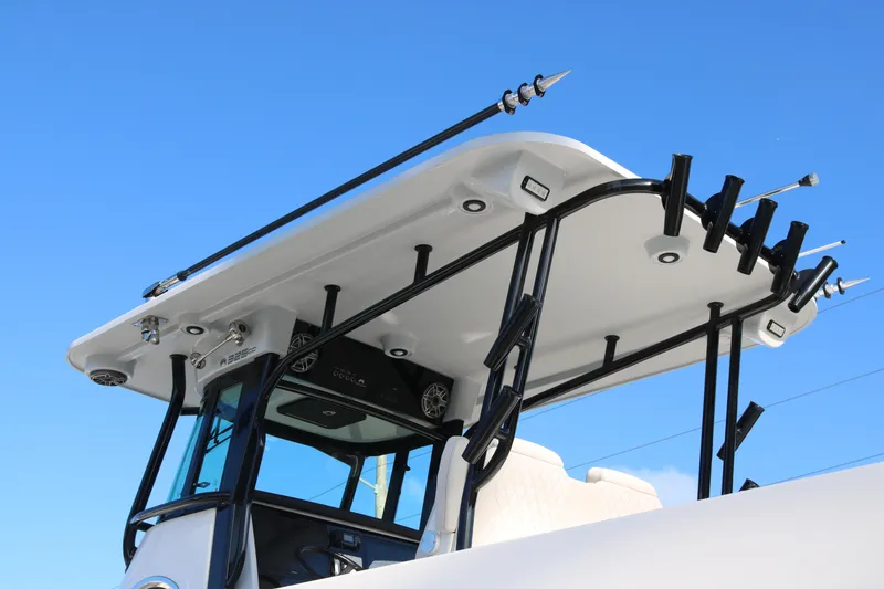 Slide: The Image of 2024 World Cat 325 CC boat top with rod holders against clear blue sky. - 5