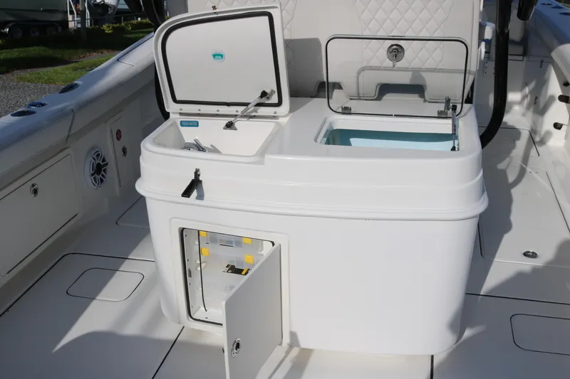 Slide: The Image of 2024 World Cat 325 CC boat interior with open storage compartments and fresh water access. - 9