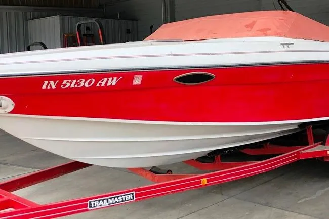 Slide: The Image of 1991 Rinker 236 Captiva Cuddy Cabin boat on a red trailer in a garage. - 10