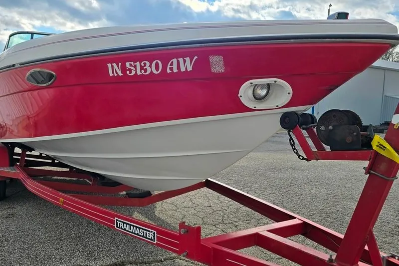 Slide: The Image of 1991 Rinker 236 Captiva Cuddy Cabin on red trailer, parked outdoors. - 11