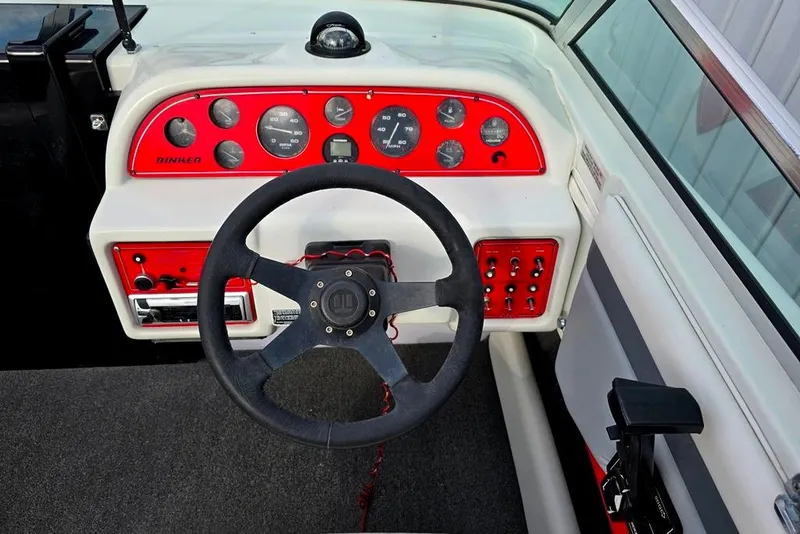 Slide: The Image of 1991 Rinker 236 Captiva Cuddy Cabin dashboard with red accents and steering wheel. - 17