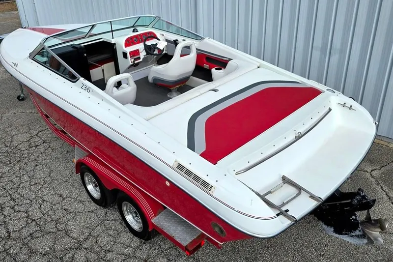 Slide: The Image of 1991 Rinker 236 Captiva Cuddy Cabin boat with red and white interior, on trailer. - 2